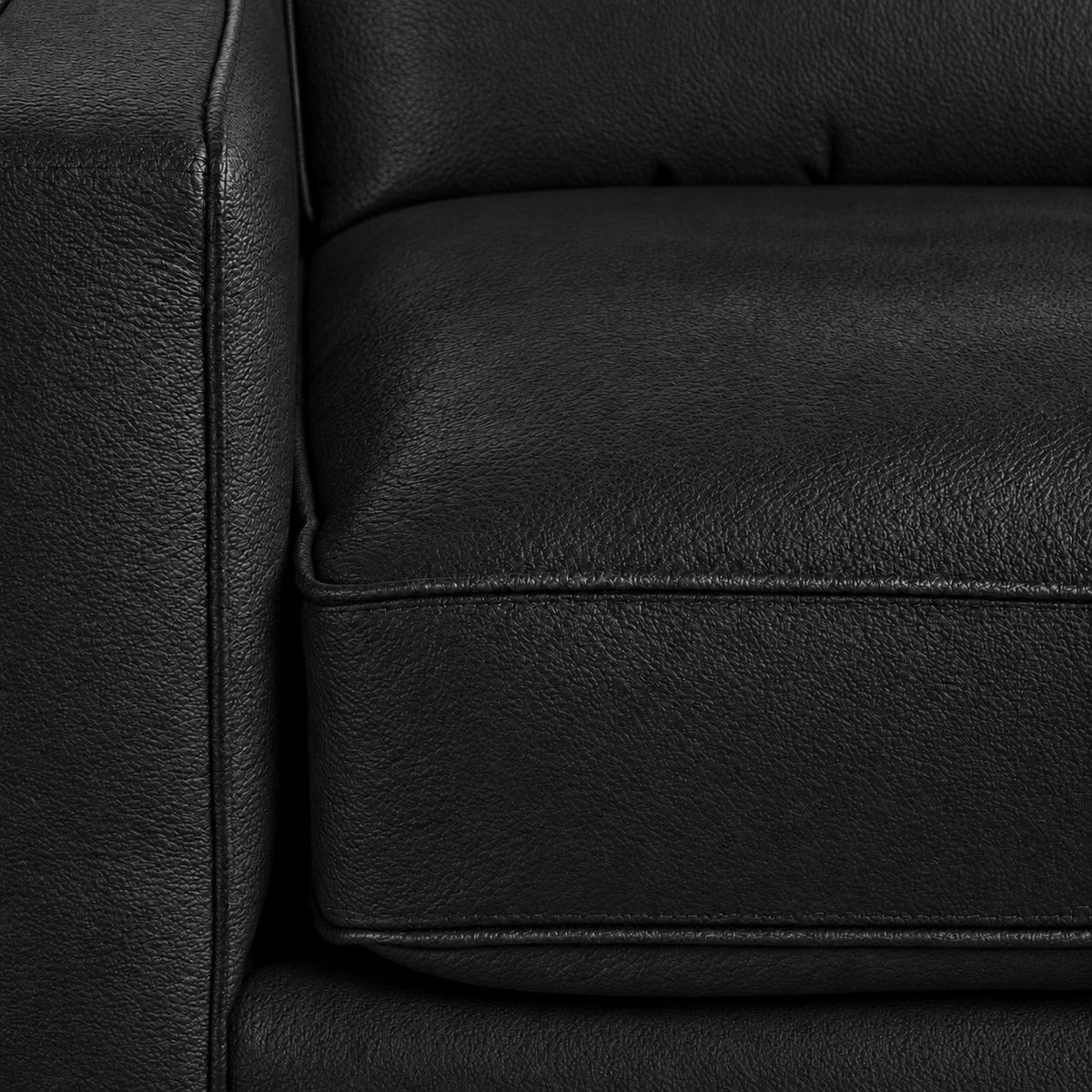 Close-up of the City Leather Sofa - Black showing the leather grain, piped seat cushion and matching upholstered arm