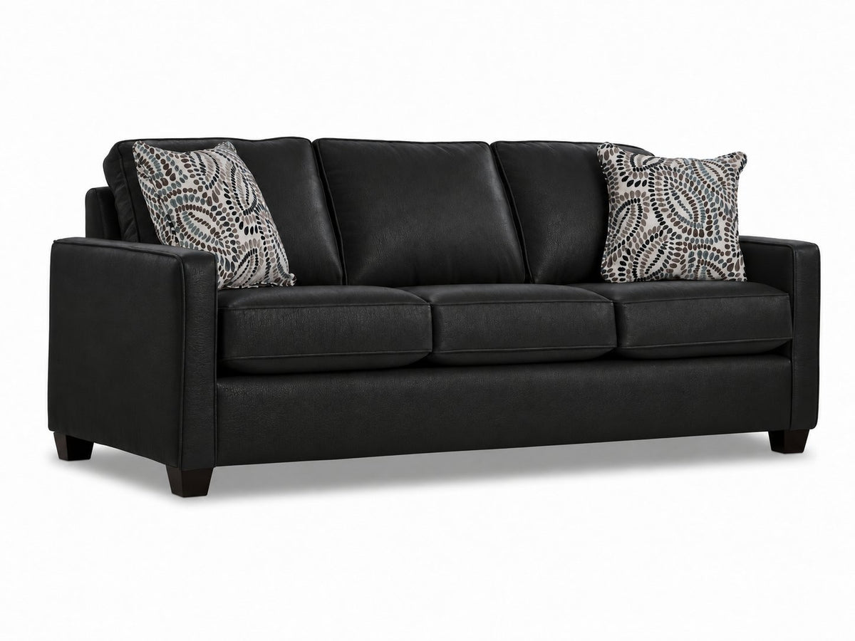 City Leather Sofa - Black in a three-quarter view with three seat cushions, slim track arms, dark wood legs and two patterned accent pillows