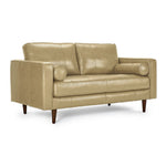 Bari Leather Loveseat in stone, shown at an angle with two back cushions, tufted bench seat, cylindrical bolster pillows and tapered wood legs