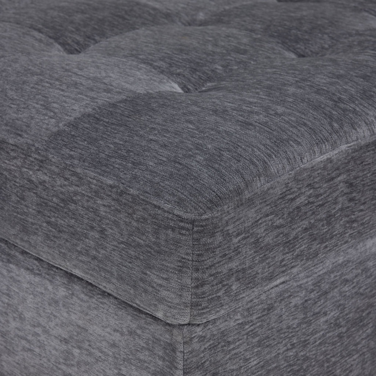 Close-up of Jayce sectional grey textured upholstery and tufted seat cushion with piped edge
