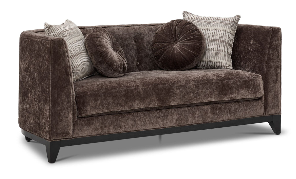 Tresor dark brown loveseat with curved back, button-tufted detail, accent pillows and angled front view