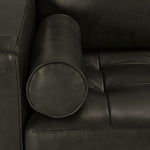 Close-up of the Bari charcoal leather upholstery, cylindrical bolster pillow and tufted seat cushion