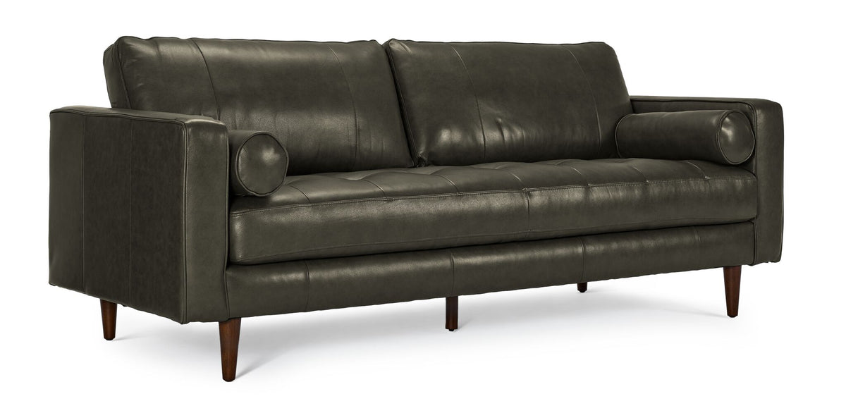 Bari Leather Sofa in charcoal shown from a three-quarter angle with tufted seat, bolster pillows and tapered wood legs