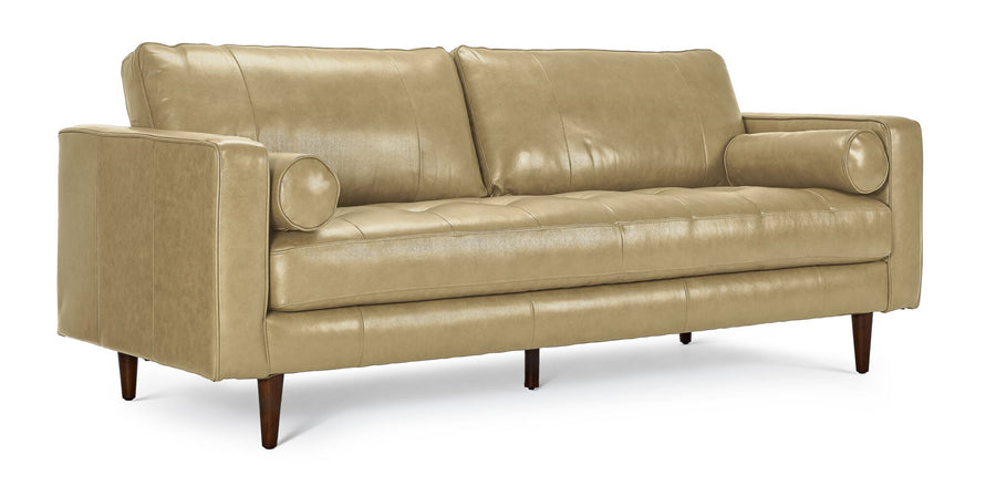 Bari Leather Sofa in stone, shown at an angle with two back cushions, tufted bench seat, cylindrical bolster pillows, track arms and tapered wood legs