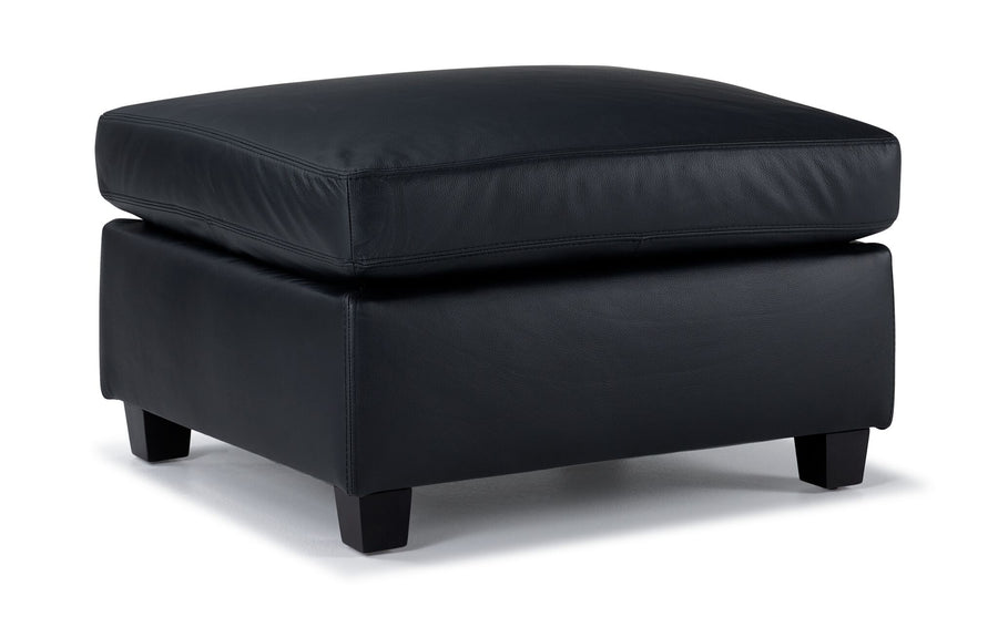 Icon Leather Ottoman - Black, angled view with thick rectangular leather cushion and dark wood feet